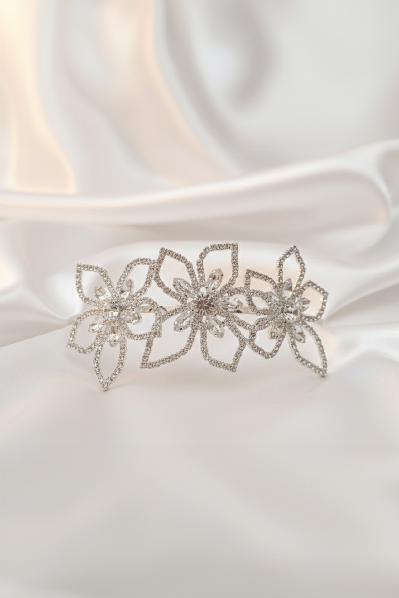 Silver floral tiara with precisely cut clear crystals arranged in a blooming flower pattern.