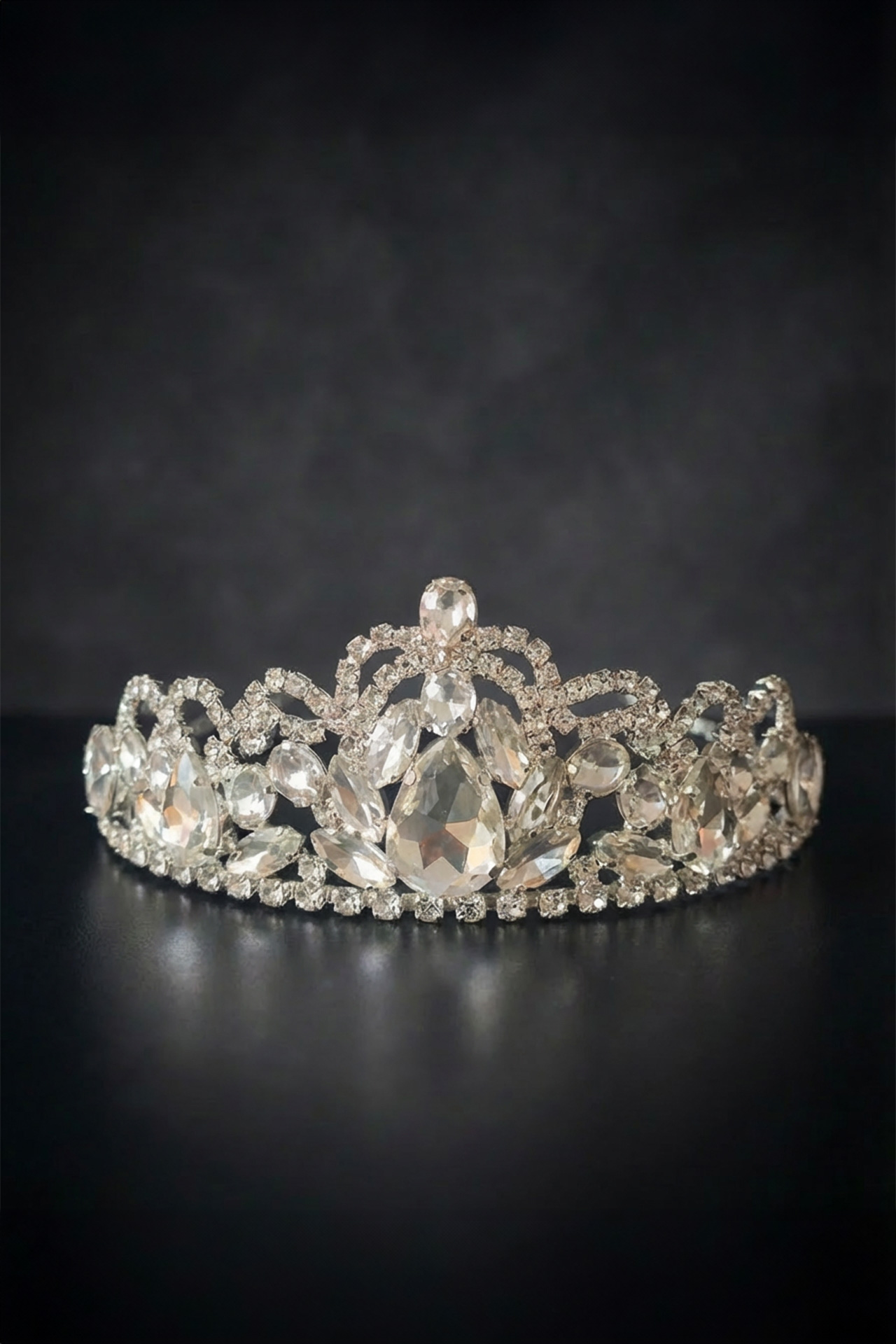 Silver tiara with a veil-like pattern of sparkling clear crystals and intricate handcrafted metalwork.