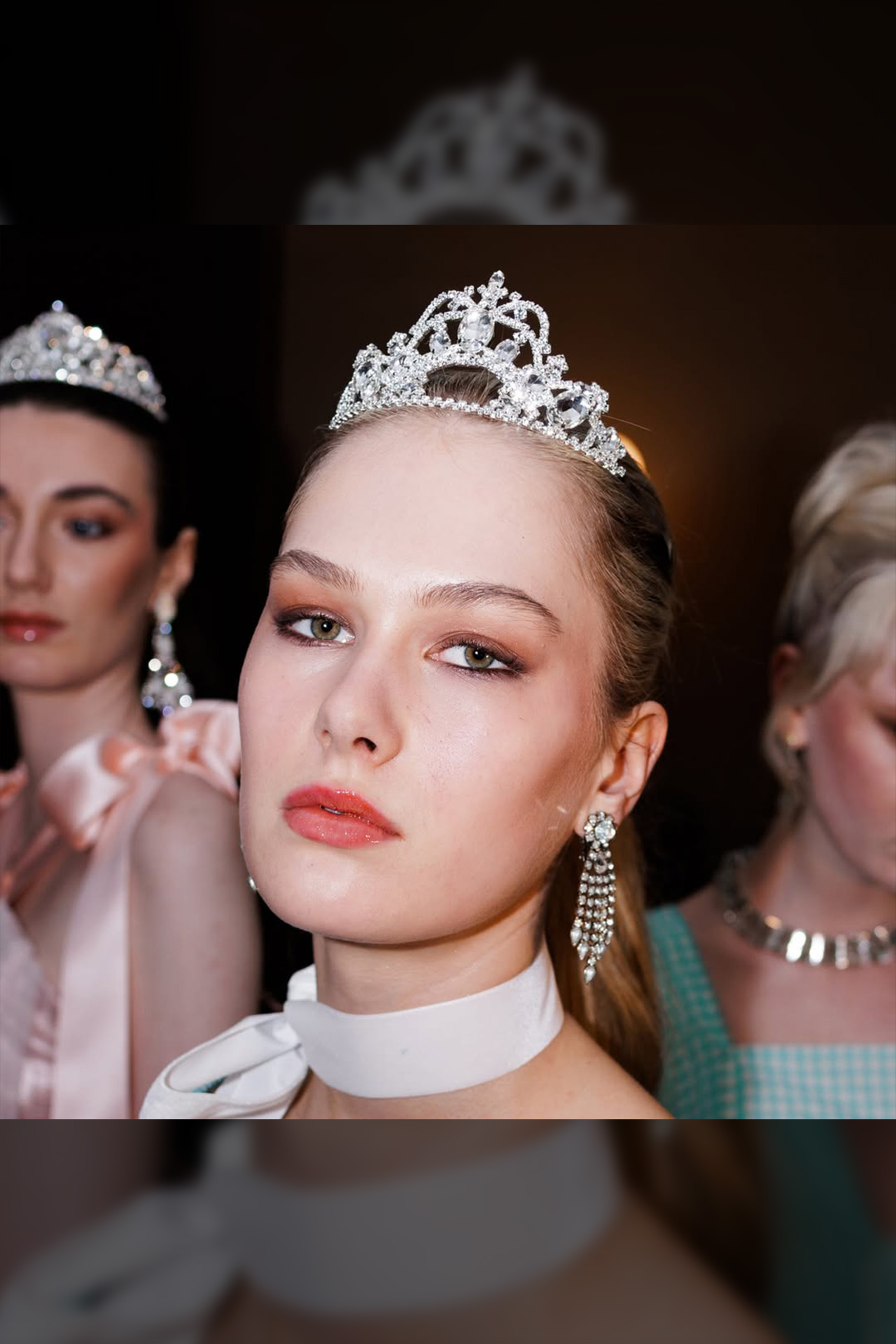 Silver crown tiara featuring a large central crystal surrounded by symmetrical patterns of smaller clear rhinestones.