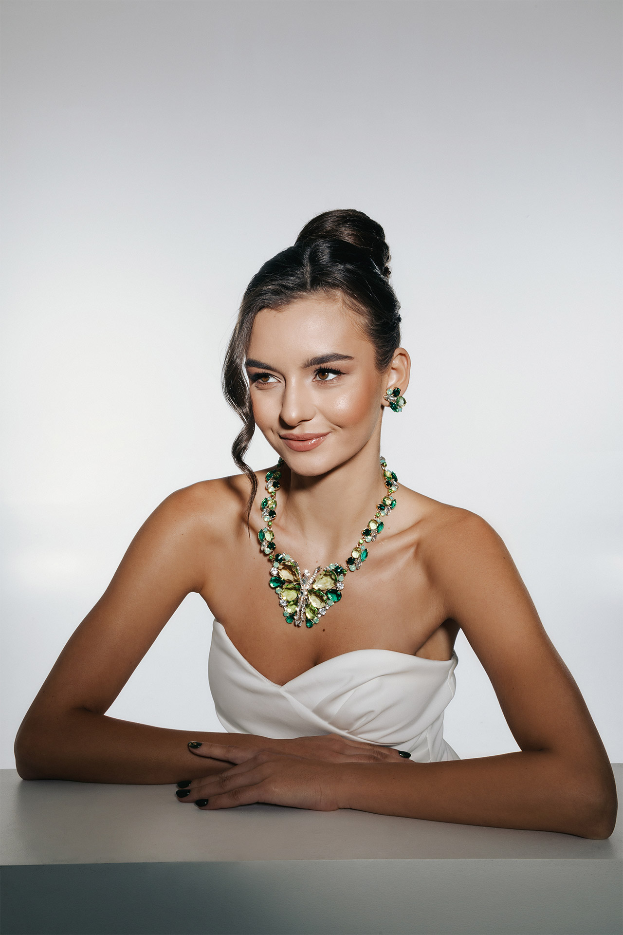 Rhinestone necklace and earrings set featuring a green crystal butterfly