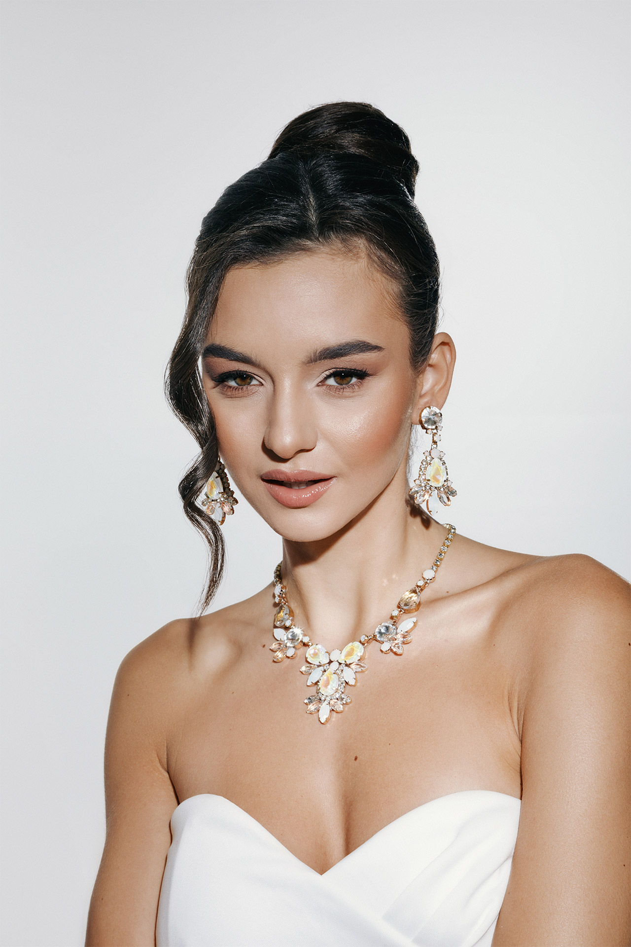 Necklace and earrings with opal-toned crystals in teardrop and round shapes