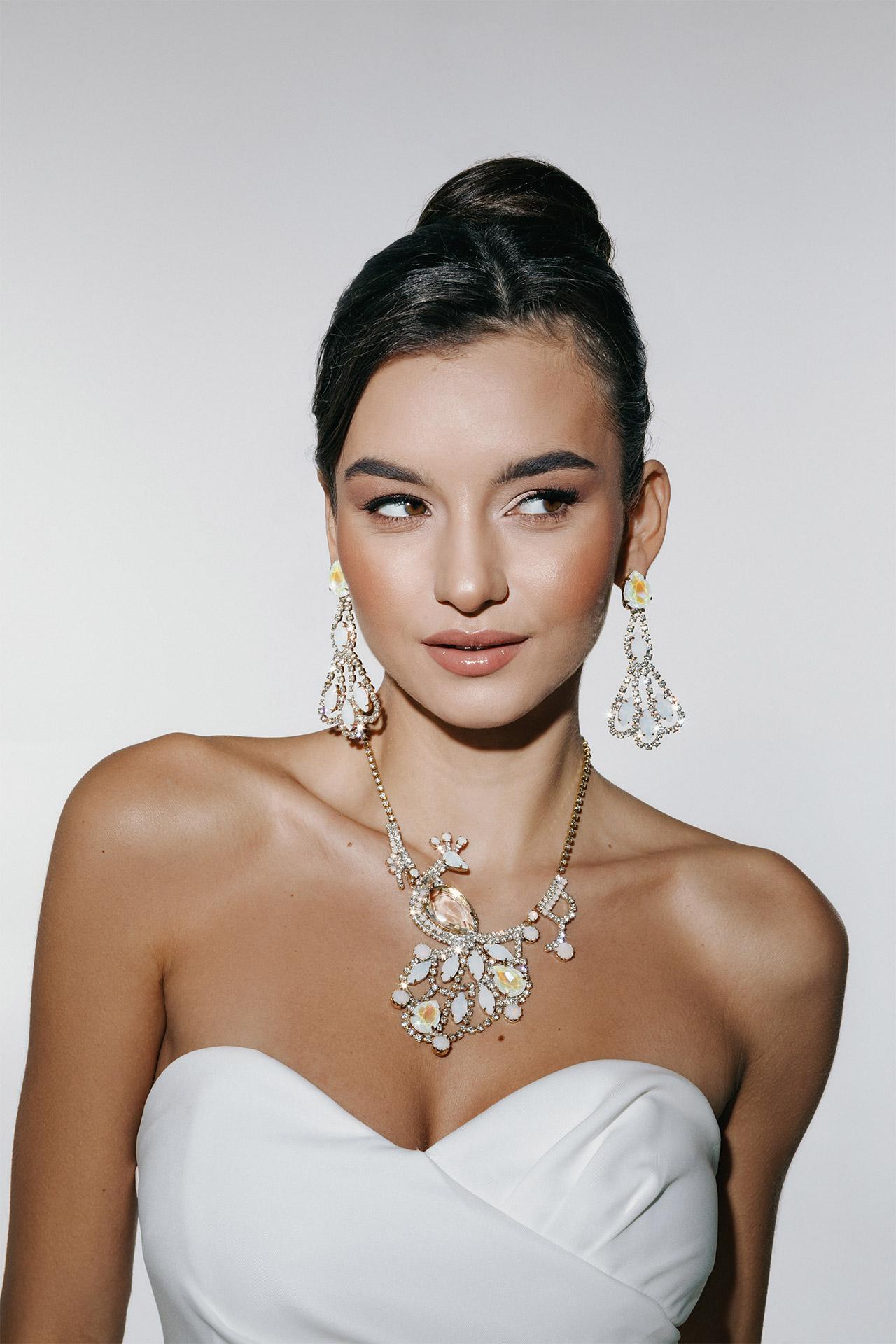 Rhinestone necklace featuring a peacock design, with matching earrings