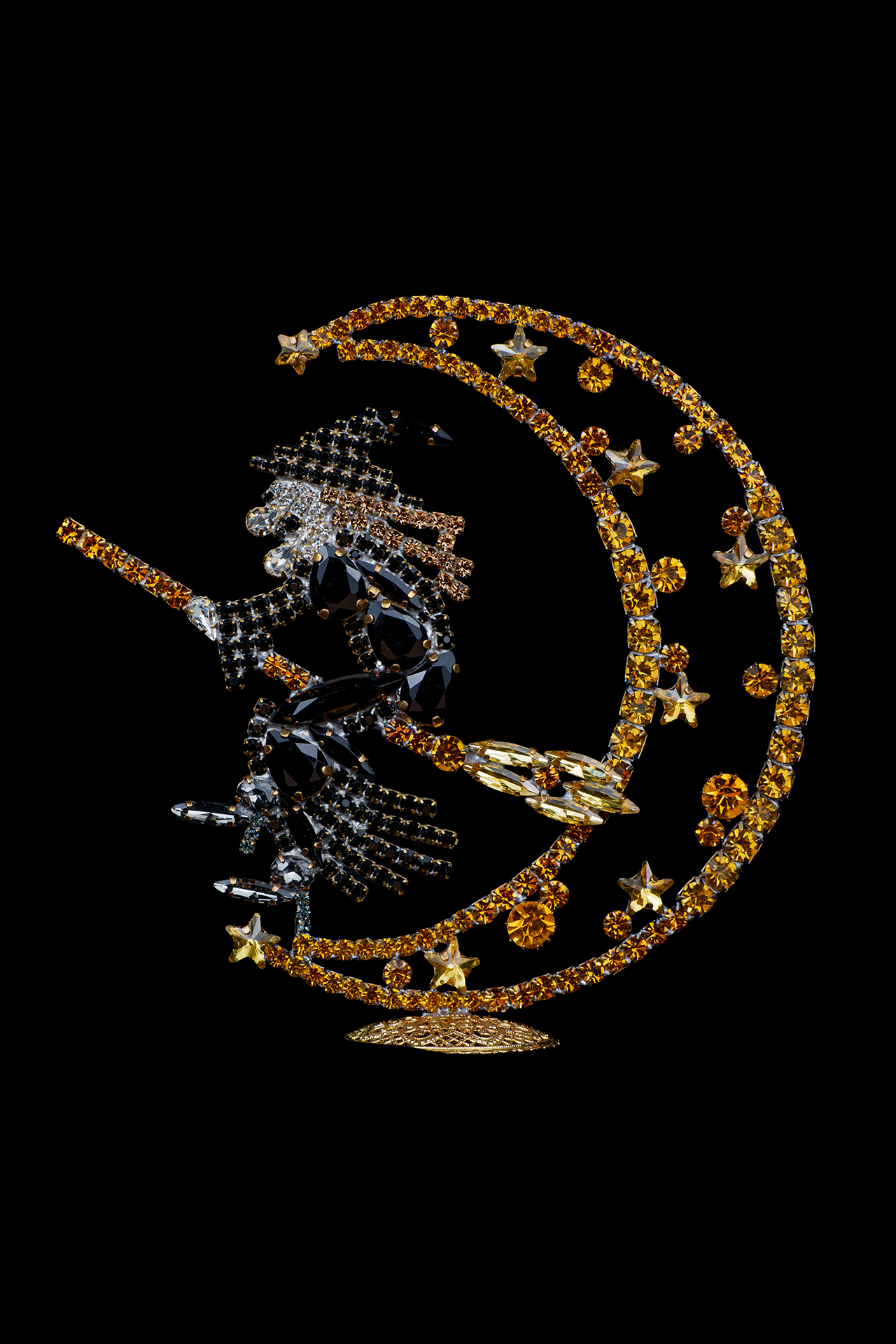 Rhinestone witch flying on a broomstick, sitting on a crescent moon.