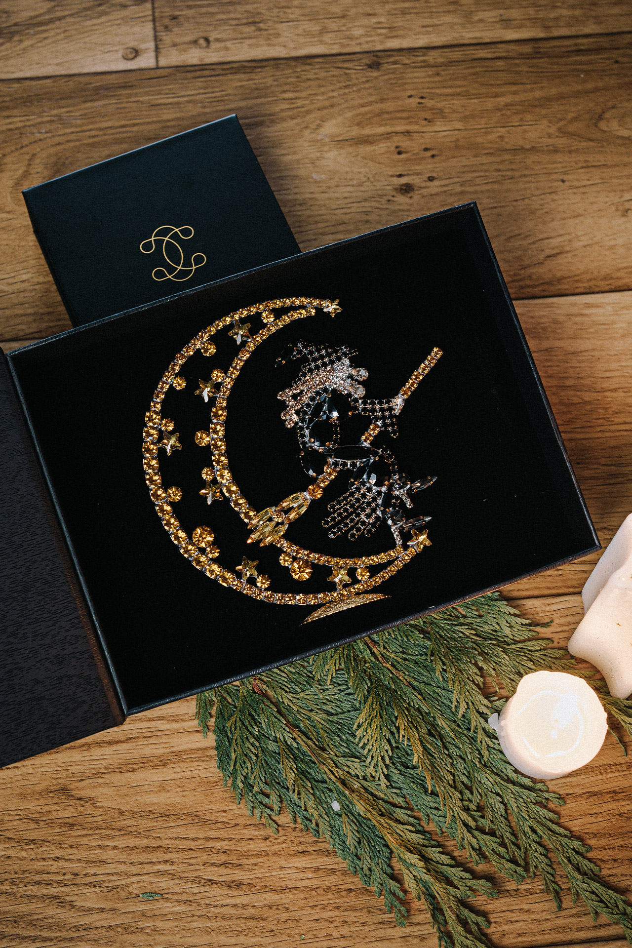 Right facing rhinestone witch flying by the moon