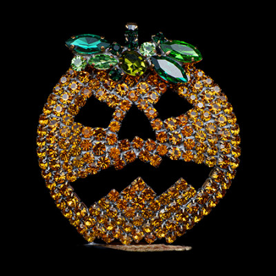 Rhinestone pumpkin with carved jack-o’-lantern face.