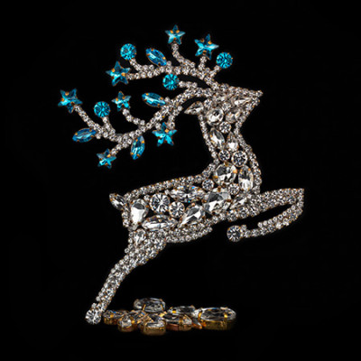 Rhinestone reindeer figurine with yellow rhinestones - facing right.
