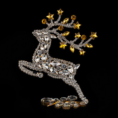 Decorative reindeer figurine with yellow rhinestones - facing left