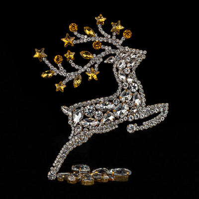 Decorative reindeer figurine with yellow rhinestones - facing right.